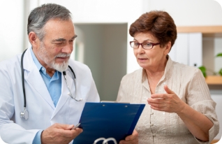 Medical exam stock photo: mature female patient wearing glasses tells the doctor about her health complaints.