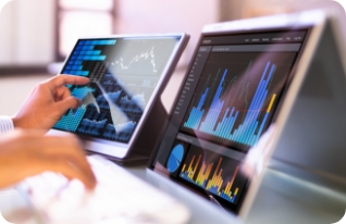 Stock image of African businessman using analytics data KPI dashboard tech. Close-up view of two laptop screens depicting infographics.